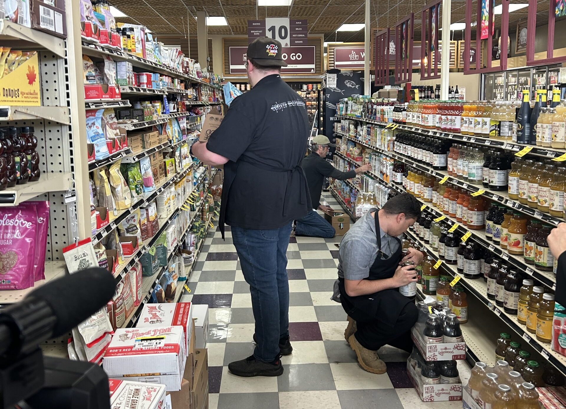 CR&E picture Two Commonwealth Autism interns in the Career Readiness & Employment program stock shelves in Good Foods Grocery in Richmond VA.