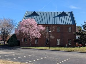 All Abilities Innovation and Inclusion Center picture of a brick building with cherry blossom tree out front where job fair will be located